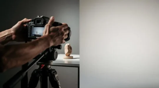 Photographe professionnel ajustant le cadrage d'une prise de vue produit selon la règle des tiers dans un studio lumineux